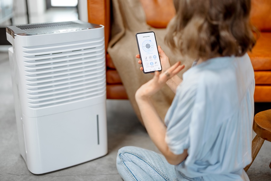 Climatizador portátil controlado por aplicación móvil en entorno doméstico, ilustrando su funcionalidad frente a un ventilador en el análisis climatizador vs ventilador.