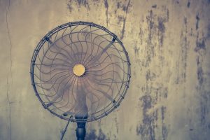 Ventilador de diseño industrial con aspas metálicas, representando un modelo clásico vinculado al origen del primer ventilador de la historia.